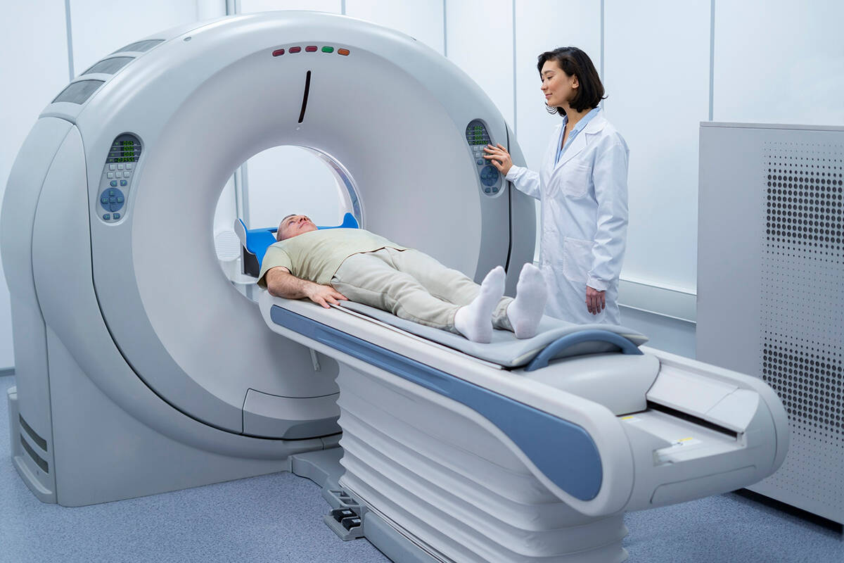 MRI Specialist with a patient going in to the machine for a scan