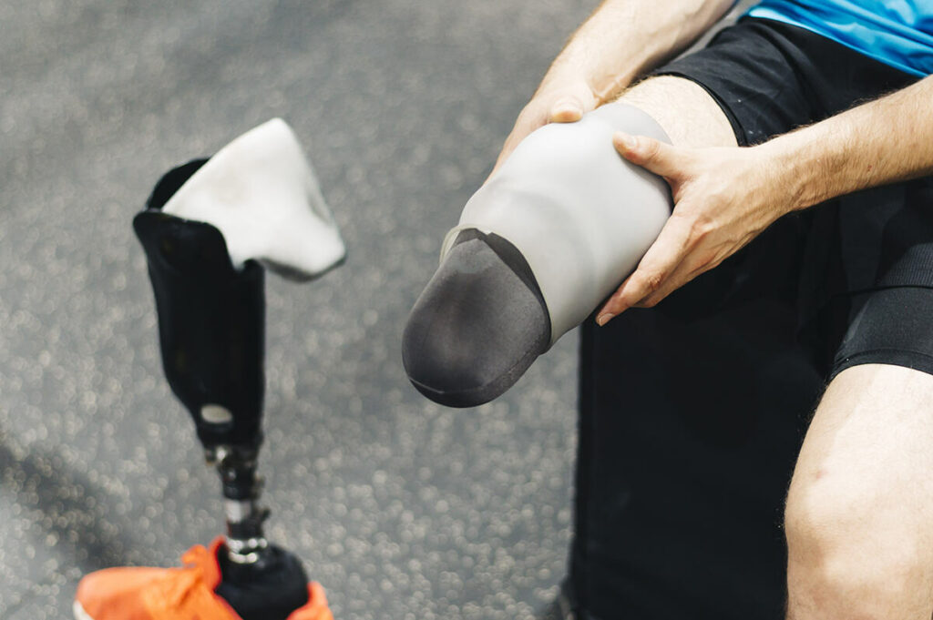 Man putting on a prosthetic liner before workout