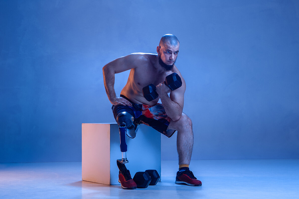 Man working out sitting down being amputated above the knee