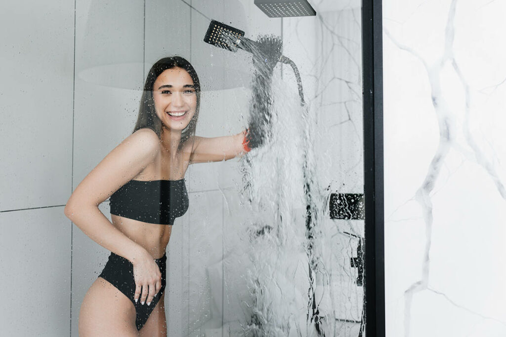 Happy smiling attractive woman with an prosthetic arm taking a shower