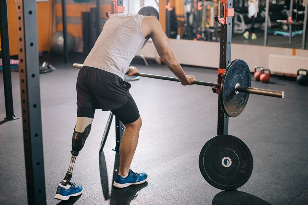 An below the knee amputee working out in the gym with barbells