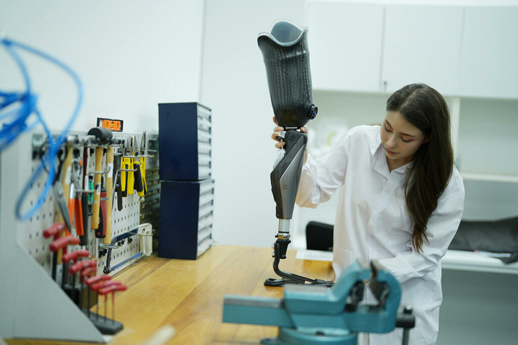 Female technician working on an above the knee prosthesis in the office aligning the foot with the socket and knee