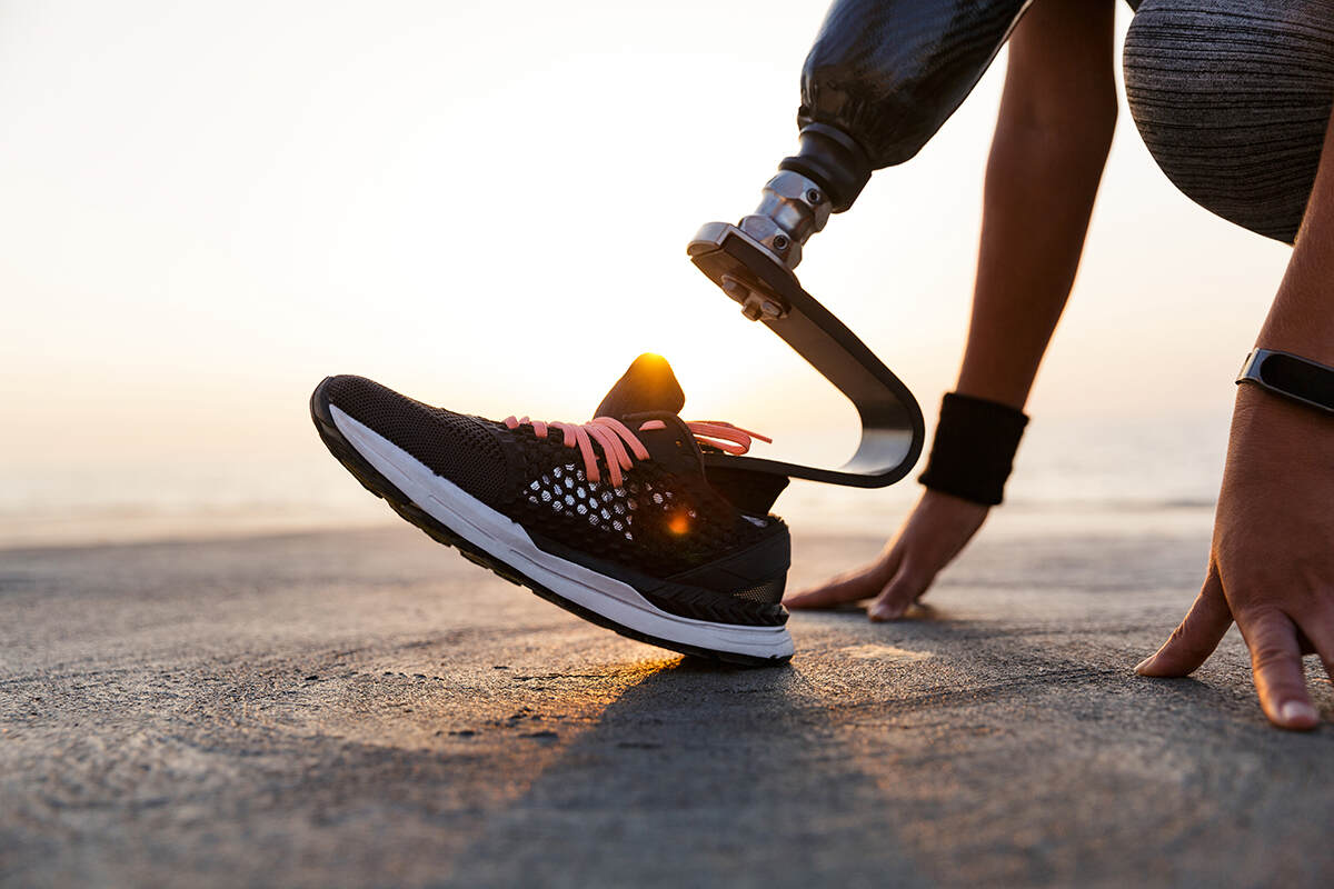Woman stretching outdoors wearing an everyday running foot prosthetic with sneakers