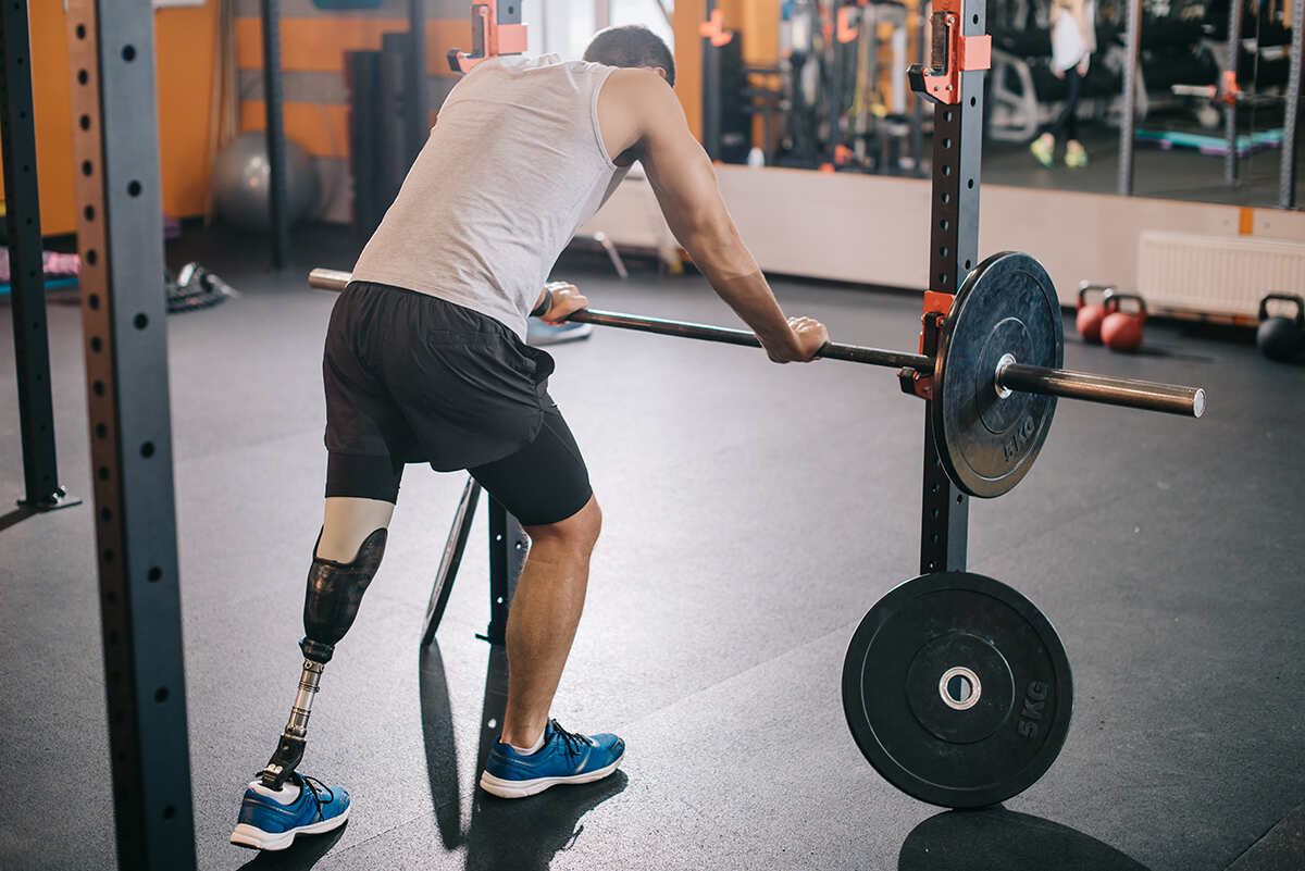 Below the knee amputee working out in the gym with barbells