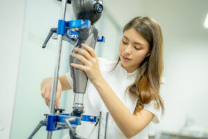 Orthopedic technician making adjustments on a prosthetic leg