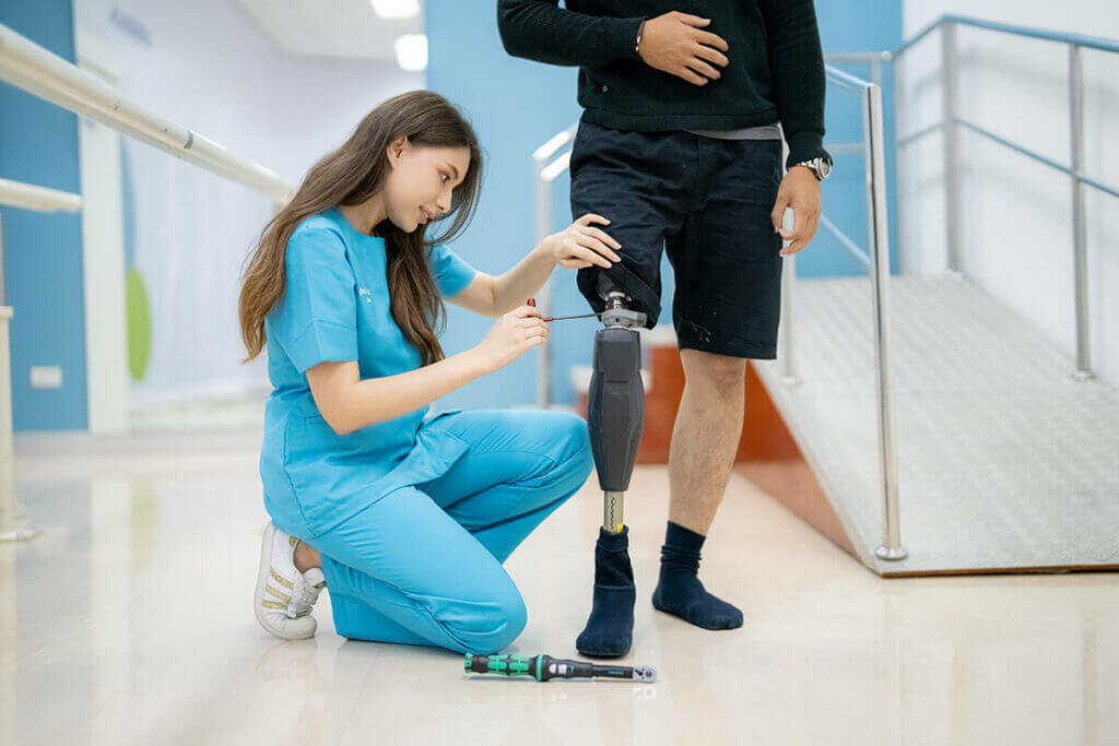 Technician adjusting a patients above the knee socket and knee and leg prosthetic parts