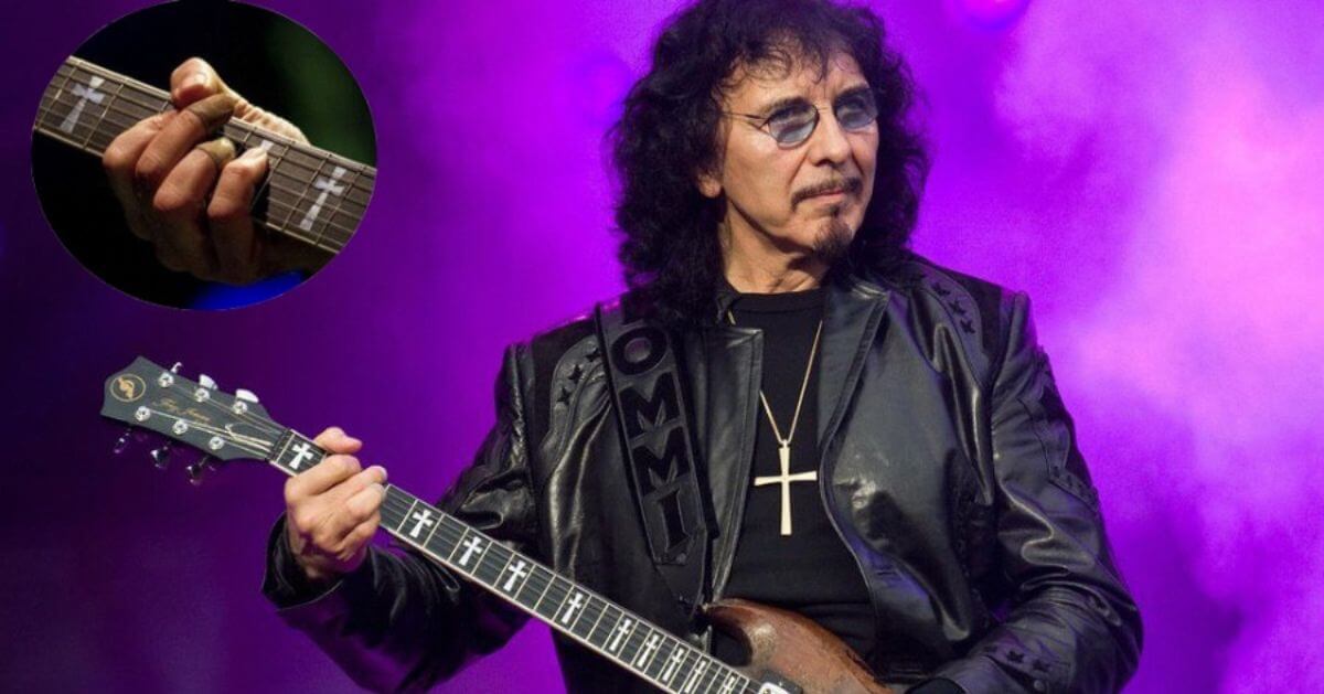 Tony Iommi, guitarist for Black Sabbath, performing live on stage. An inset image shows a close-up of his hand, which is missing the tips of two fingers.