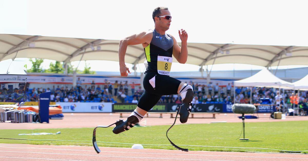Oscar Pistorius, a Paralympic athlete, running on a track with carbon-fiber prosthetic legs during a competition.