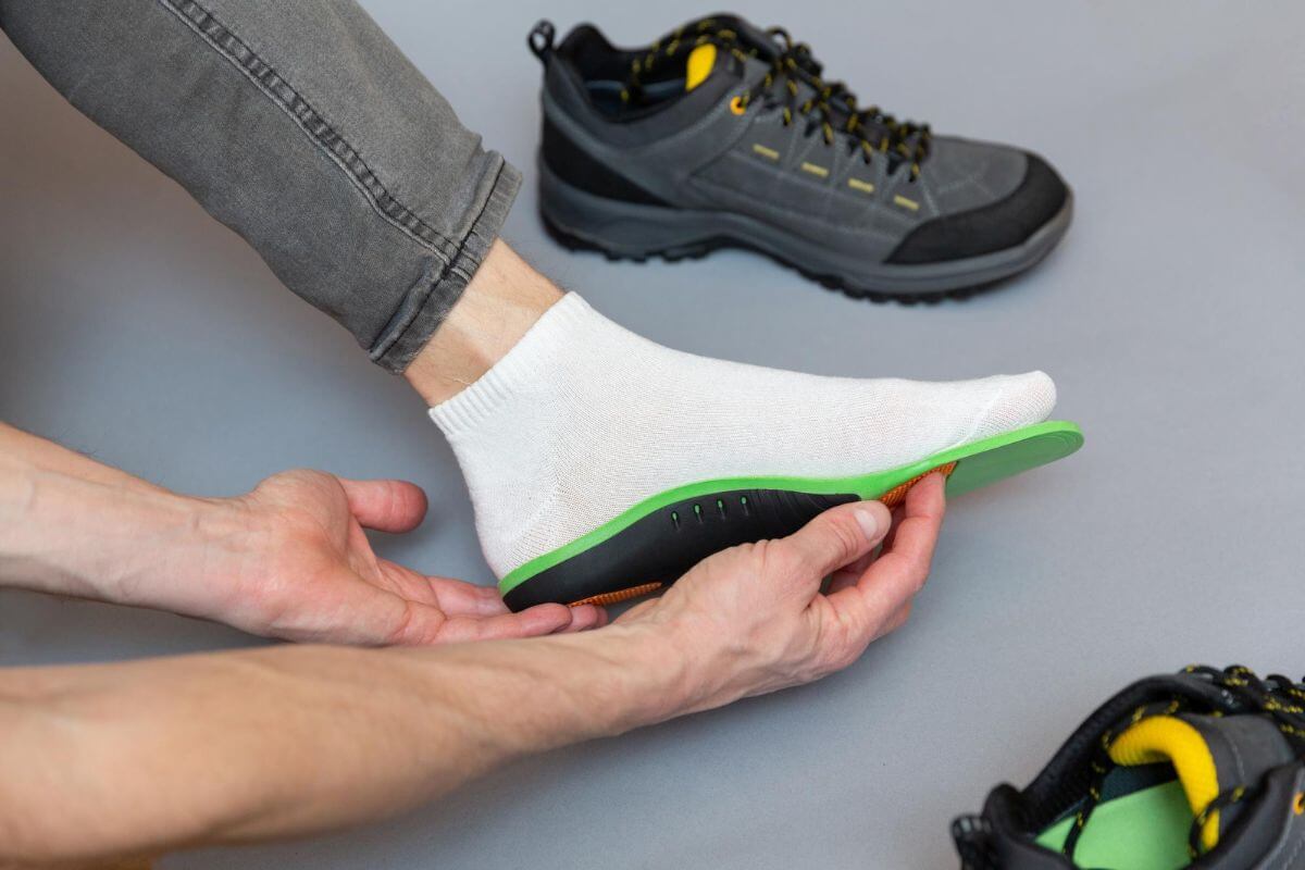 Person placing his/her foot on custom orthotics