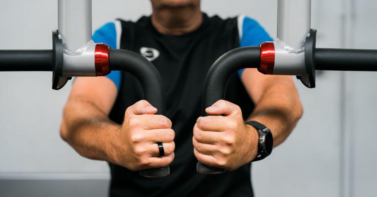 A person holding the handles of a gym machine