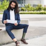 Business professional with a prosthetic leg sitting outdoors and reviewing a paperwork.