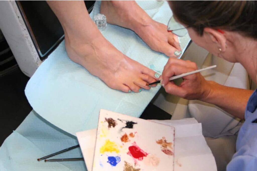 A prosthetist carefully paints details on a silicone prosthetic toe, matching the natural skin tone and creating realistic details for a lifelike appearance. Photo credits to Medical Art Prosthetics