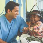 Child wearing a halo brace sitting with a healthcare provider