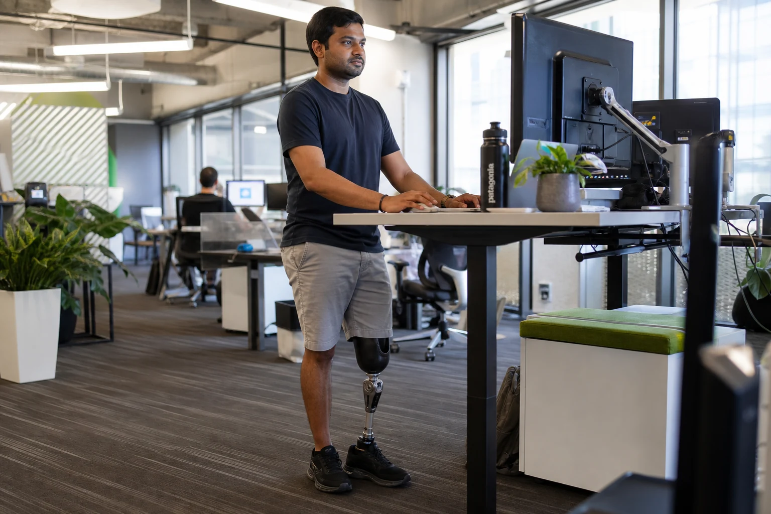 Man with a prosthetic leg working at a standing desk in a Silicon Valley technology office