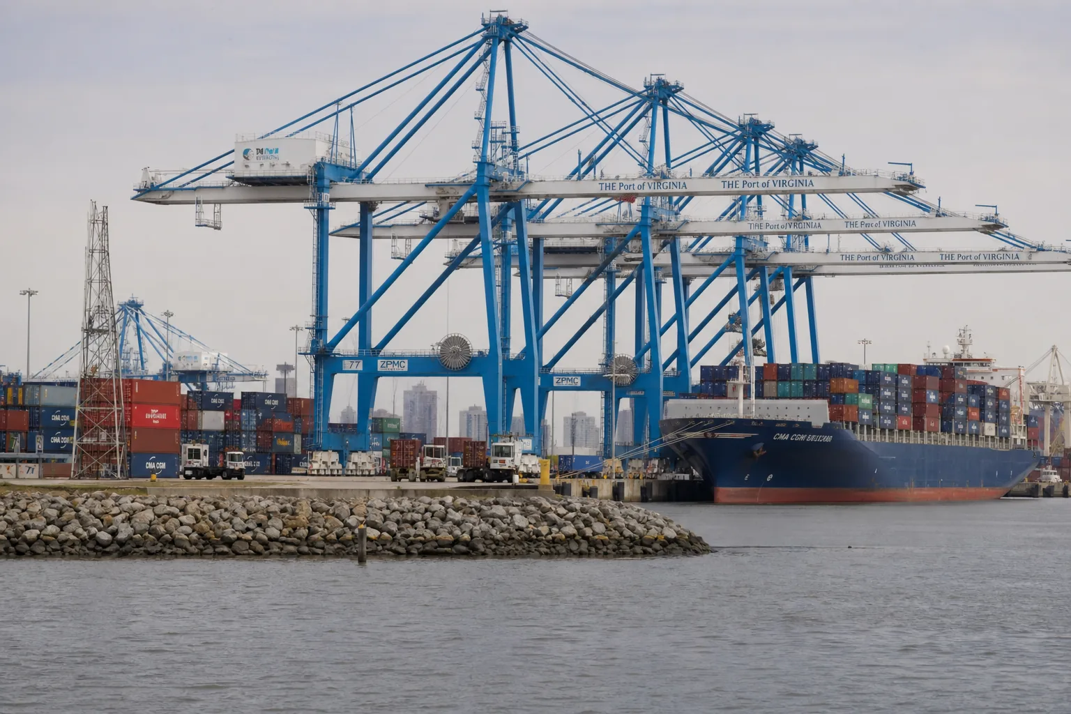 Cargo cranes and stacked shipping containers at a Virginia port terminal on the river
