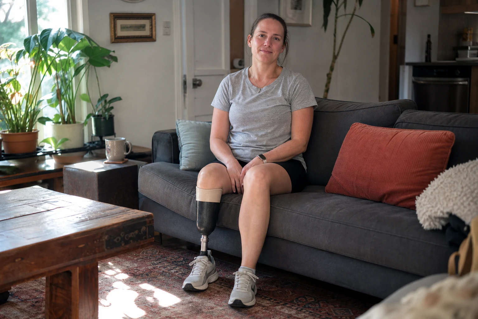Woman with a below-knee prosthetic leg sitting at home in California