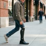 Amputee walking on a city sidewalk with an advanced AI-powered bionic prosthetic leg