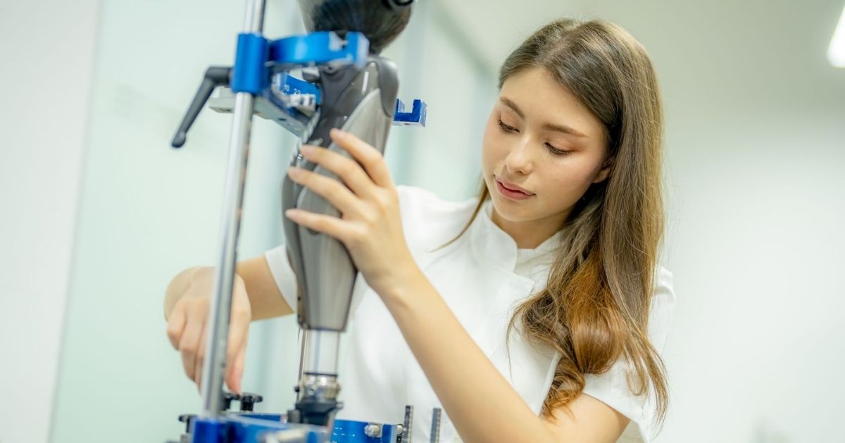 Prosthetist aligning and adjusting a prosthetic leg using a laboratory alignment stand.