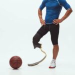 Below-knee amputee athlete wearing a running blade standing beside a basketball.