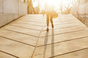 Woman with a below-knee prosthetic leg walking up an outdoor ramp
